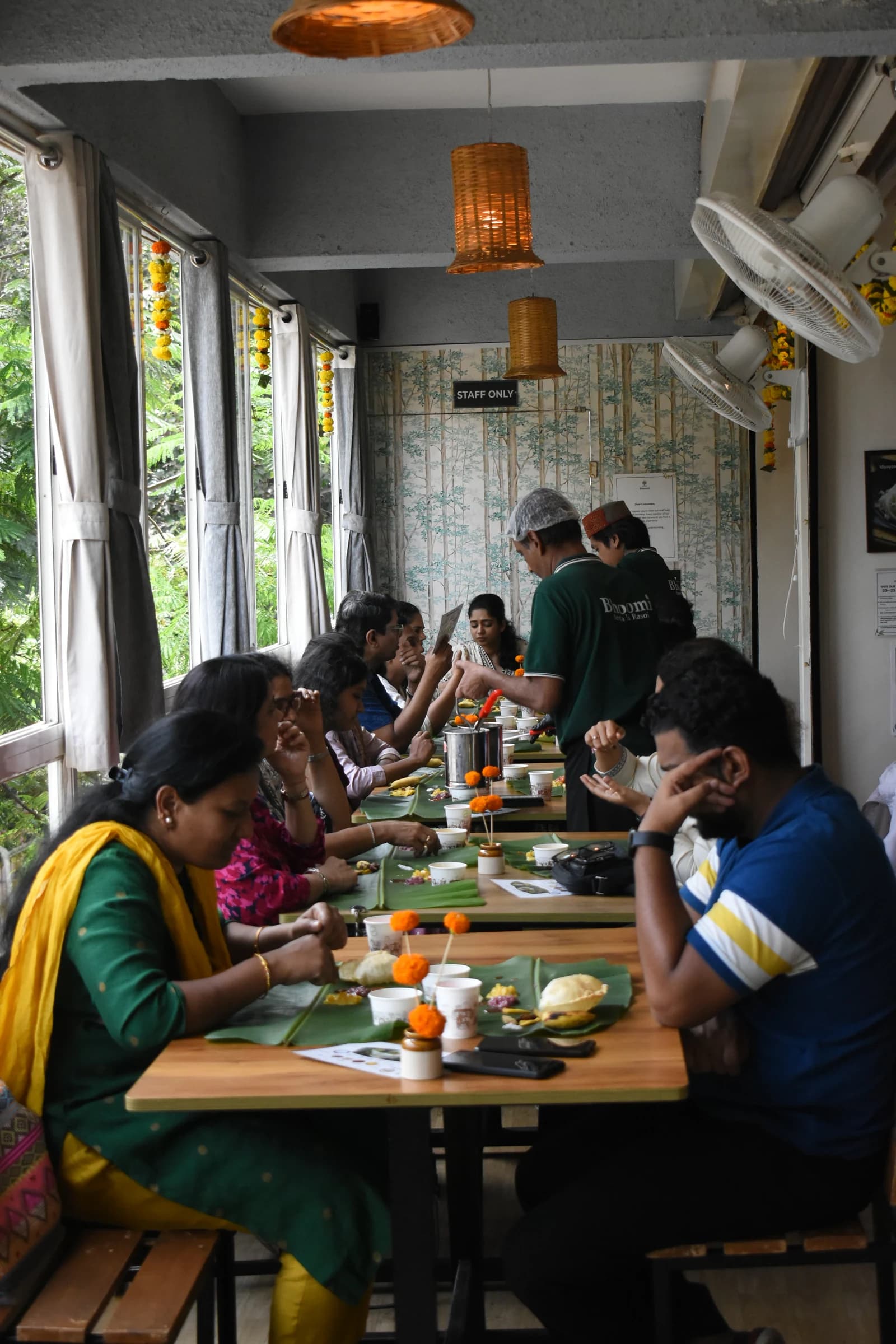 The Bhoomi team serving a traditional Sadhya along a full table
