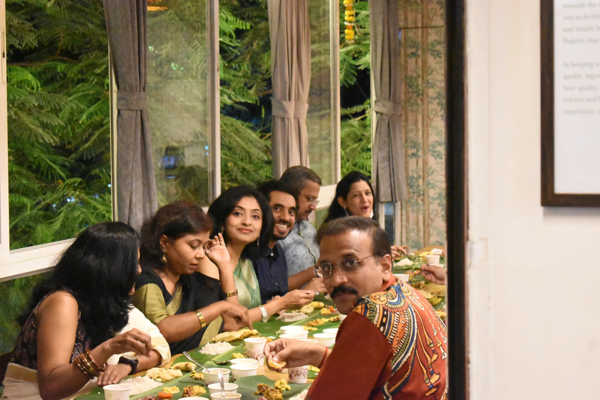Friends sharing the Sadhya by Bhoomi's green windows
